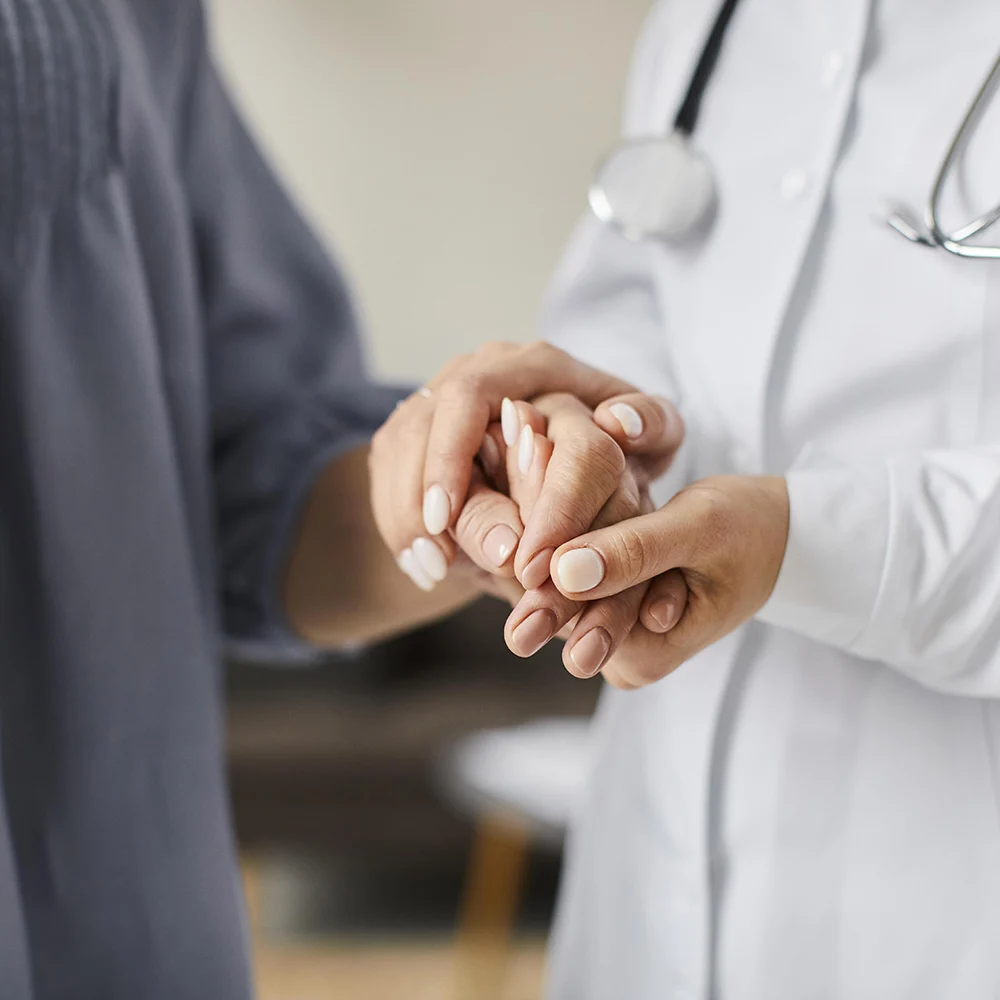 Medico che tiene la mano ad una paziente